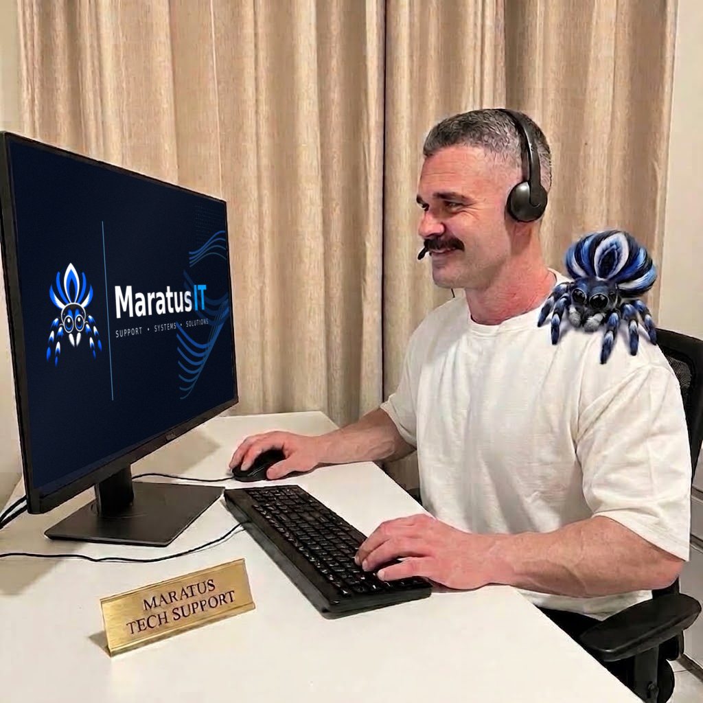 Ryan at his desk wearing a headset, with the Maratus IT logo on his monitor and a blue peacock spider on his shoulder